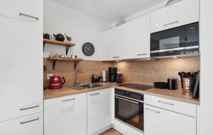 eine weiße Küche mit Spüle und Mikrowelle in der Unterkunft Lodge Am Deich in Tossenserdeich