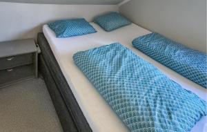 2 blaue Kissen auf einem Bett in einem Zimmer in der Unterkunft 3 Bedroom Cozy Home In Farsund in Farsund
