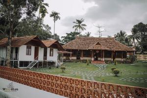 a house with a garden in front of it at Woodlyn Homestay & Boating in Munroe Island