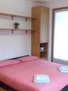 una camera con un letto rosa con una coperta rosa di Residenza Capinera a Bormio