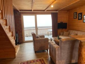 a living room with a couch and a large window at Villa Te Ibra - Rugovë in Peje