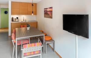 cocina pequeña con mesa y TV de pantalla plana en Nice Apartment In Søgne With Wifi, en Søgne