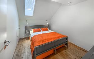 1 dormitorio con cama con sábanas de color naranja y ventana en Nice Apartment In Søgne With Wifi, en Søgne