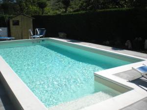 a swimming pool with two chairs in the water at Casetta n.2 con piscina in Sarola