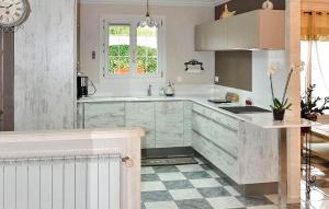 a kitchen with white cabinets and a sink and a window at Cozy Home In Chateaurenard in Châteaurenard