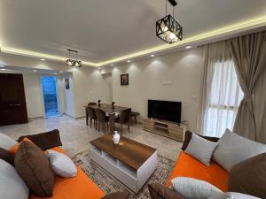 a living room with a couch and a table at 209 . Spacious 3BR Apt. 2 Baths Gated Community in Sheikh Zayed
