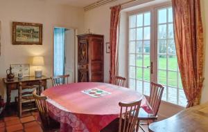 a dining room with a table and a window at Gorgeous Home In Plélan-Le-Petit in Plélan-le-Petit
