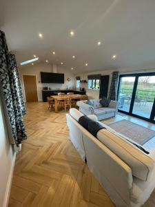 un salon avec deux canapés et une salle à manger dans l'établissement The Old Potting Shed - 2 bed cottage with hot tub, à Low Catton