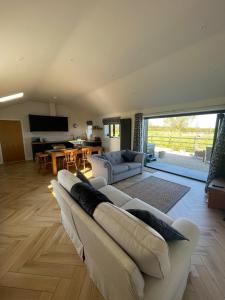 un salon avec un canapé blanc et une table dans l'établissement The Old Potting Shed - 2 bed cottage with hot tub, à Low Catton 41 autres photos