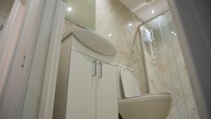 a white bathroom with a sink and a toilet at Prestige Stays Cardiff Modern 2-Bedroom Duplex Apartment near City Centre Wi-Fi & Lockbox Check-In in Cardiff