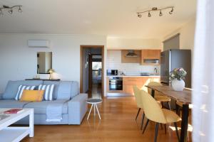 un salon et une cuisine avec un canapé et une table dans l'établissement Saronida Seaside Serenity, à Saronida