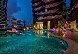 una piscina di fronte a un edificio di notte di Arte Plus Jalan Ampang Two Bedrooms by V Stay a Kuala Lumpur
