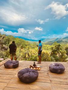 two men standing on top of a wooden deck with bean bags at Richiland Tea Estate Bungalow in Deniyaya +28 photos