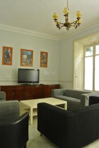 een woonkamer met banken en een tv bij Pensión Santa Paula in Málaga