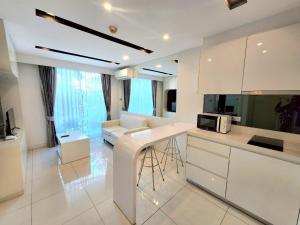cocina blanca con sofá y microondas en City Center Residence NEW, en Pattaya central
