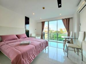 a bedroom with a pink bed and a large window at City Center Residence NEW in Pattaya +74 photos