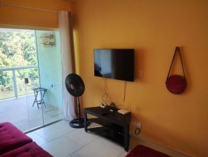 ein Wohnzimmer mit einem Flachbildfernseher an der Wand in der Unterkunft Apartamento completo Mangaratiba in Mangaratiba + 5 Fotos