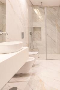 a white bathroom with a sink and a toilet at The Eight Luxury Stay in Penafiel +27 photos