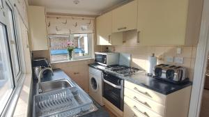 a small kitchen with a sink and a stove at Brambles Farm Bungalow in Freshwater