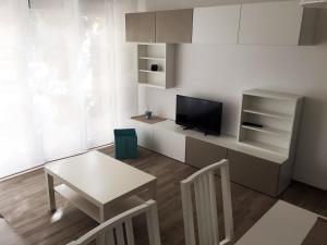 una pequeña sala de estar con mesa y TV. en semeria103, en San Remo