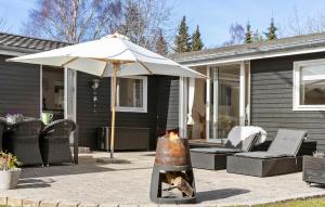an umbrella on a patio with a fire place at Nice Home In Græsted With Wifi in Græsted +10 photos