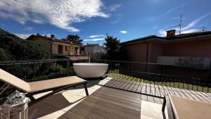 a deck with a bath tub and a bench on a balcony at Villa Giulia Rooms & Bike in Toscolano Maderno