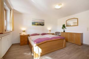 a bedroom with a bed and a dresser and a mirror at Landhaus Moos in Argenbühl