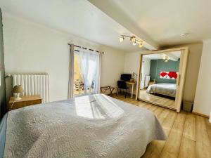 a bedroom with a bed and a large mirror at Hôtel Restaurant La Forge in Castellane