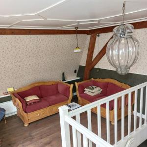 a living room with two couches and a chandelier at Bed&Breakfast ons Oda in Sint-Oedenrode