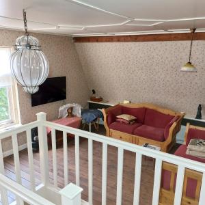 a living room with a couch and a tv at Bed&Breakfast ons Oda in Sint-Oedenrode