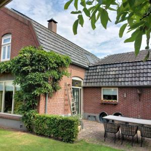 a brick house with a table and chairs in the yard at Bed&Breakfast ons Oda in Sint-Oedenrode +20 photos