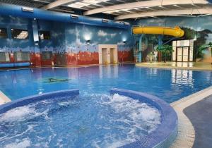 a large swimming pool with a water slide in it at The Getaway Billing Aquadrome in Great Billing