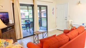 サニベルにあるSanibel Island retreat with private beachのリビングルーム(オレンジ色のソファ、バルコニー付)