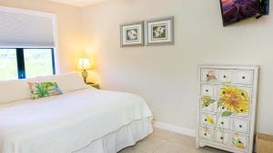 サニベルにあるSanibel Island retreat with private beachの白いベッドとドレッサーのある寝室