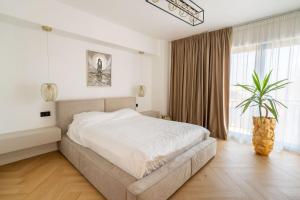 Un dormitorio con una cama y una ventana grande. en Lake view apartment - free parking, en Râmnicu Vâlcea