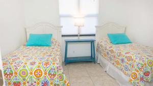 a bedroom with two beds and a table at Stylish Beachside Retreat on Sanibel Island in Sanibel +12 photos