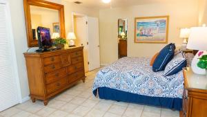 サニベルにあるEscape to Paradise - Tranquil 3-Bedroom Retreat with Wrap-Around Lanai and Private Beachのベッドルーム(ベッド1台、ドレッサー内のテレビ付) +25枚の写真