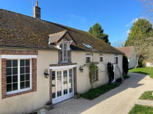 a white house with white doors and a driveway at Assarag in Brienon-sur-Armançon