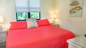 a bedroom with a red bed and a window at Poolside Paradise - Family-Friendly Villa on Sanibel Island - Private Beach in Sanibel +13 photos