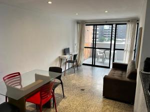 una sala de estar con una mesa y un sofá en Atlantico Flat, en Fortaleza
