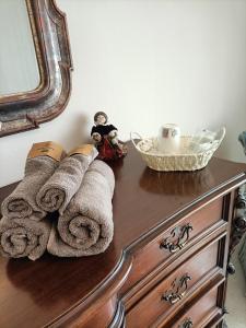 a wooden dresser with towels and a mirror on it at Casa Vacanze Annunziata Relax in Lucca +27 photos