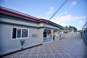 a white house with a tile driveway at The Everette Lodge in Sekondi-Takoradi