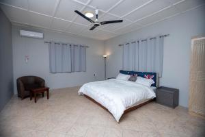 a bedroom with a bed and a ceiling fan at The Everette Lodge in Sekondi-Takoradi
