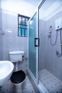 a bathroom with a shower and a toilet and a sink at The Everette Lodge in Sekondi-Takoradi +20 photos