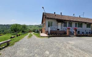 a small house on a gravel road next to a field at La Letizia in Cocconato