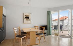a kitchen and dining room with a table and chairs at Gudhjem Søpark Lejl 19 in Gudhjem