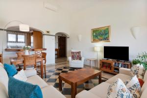 a living room with white furniture and a flat screen tv at Villa Ambar Cherry in Playa Blanca