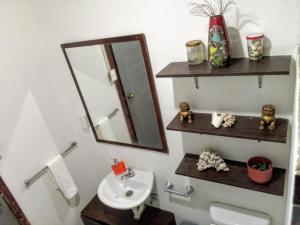 un bagno con lavandino, specchio e WC di La Fogata a Machalilla