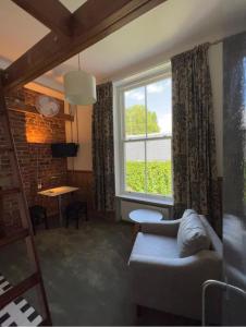 a living room with a couch and a window at Victorian Loft Living Hotel 22 in London