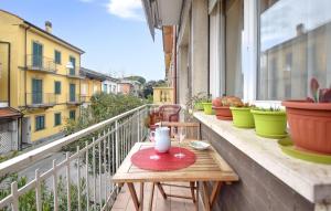 a small wooden table on a balcony with plants at Stunning Apartment In Viareggio in Viareggio